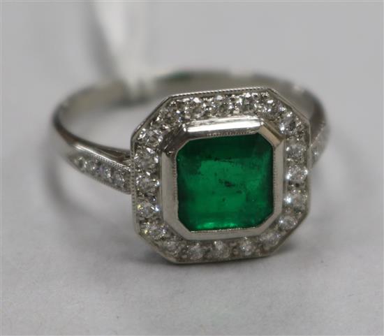 An Art Deco style platinum, emerald and diamond cluster ring, size P.